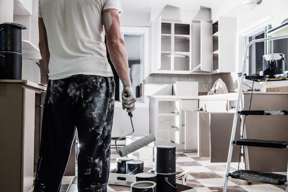 Photo of a man painting a kitchen.