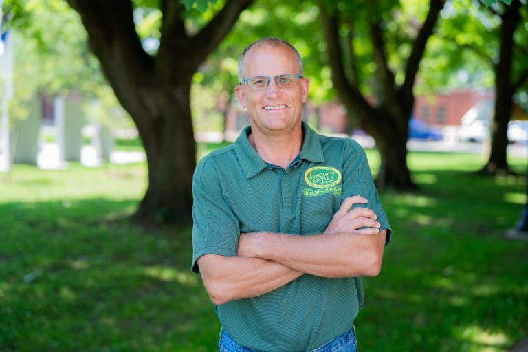Photo of a male worker from Lincoln Davies outside with his arms crossed. He is wearing a Lincoln Davies shirt.