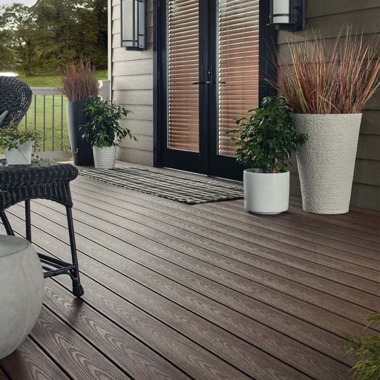 Photo of outdoor deck or patio with plants and a door.