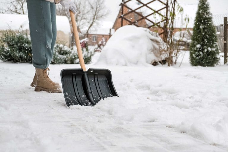 Person shoveling snow from a driveway.